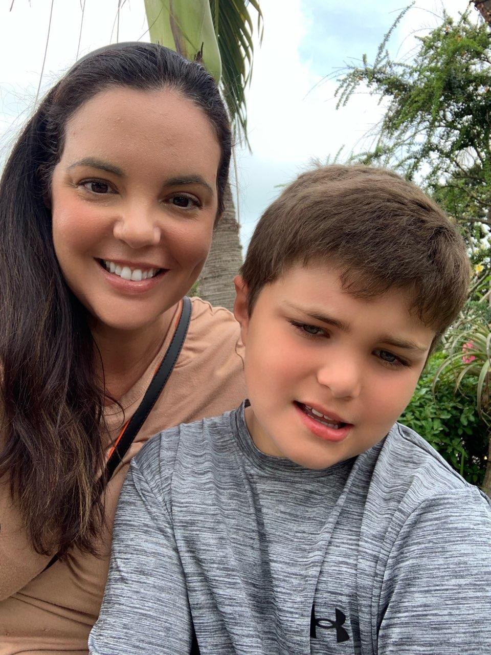 Robert and his mom, Isabel Norton, smiling outdoors under a palm tree